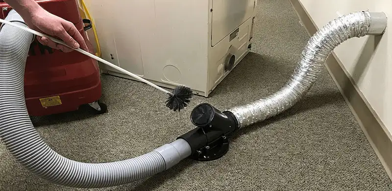 Dryer vent cleaning service removing lint from a dryer duct connection in Kansas City, KS