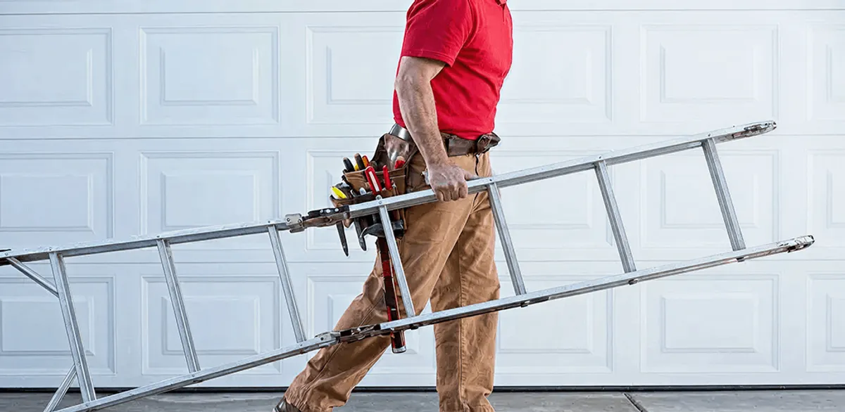Garage door repair technician arriving with tools and ladder in Kansas City, KS