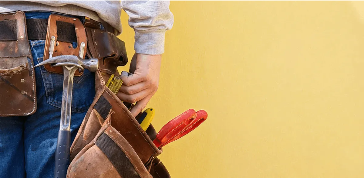 Handyman with tool belt ready for home repairs and maintenance in Kansas City, KS