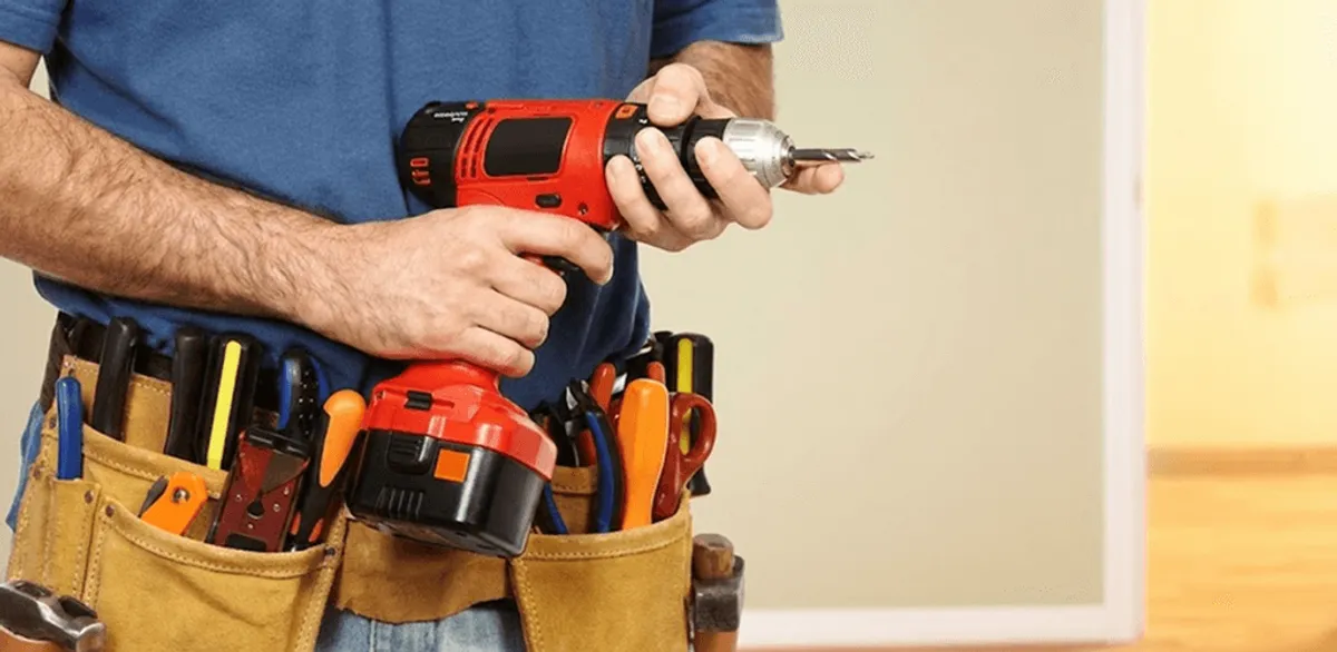 Handyman holding a power drill for home repairs and installations in Kansas City, KS