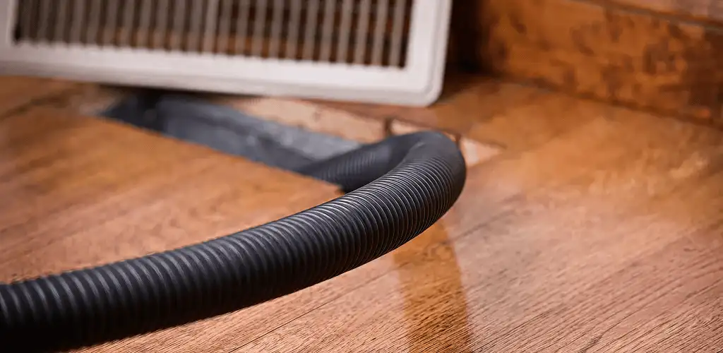 Air duct cleaning hose inserted into a floor vent for ductwork cleaning in Kansas City, KS