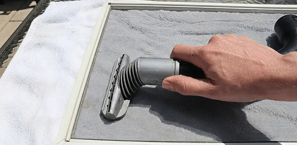 Window screen repair cleaning and fixing a damaged screen mesh in Kansas City, KS